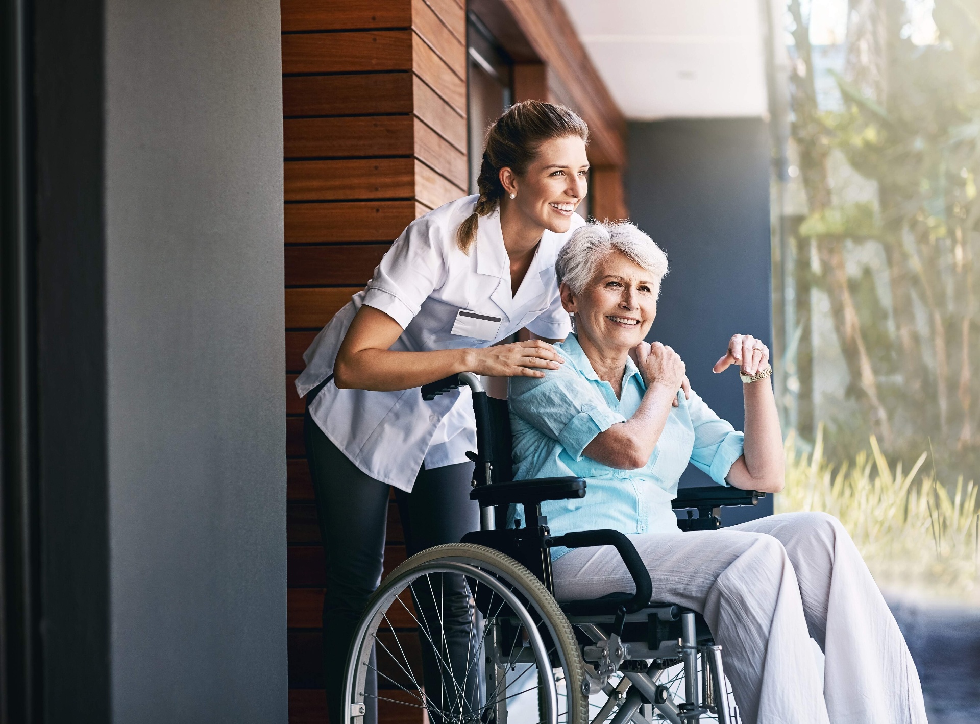 Pflegerin mit Seniorin im Rollstuhl